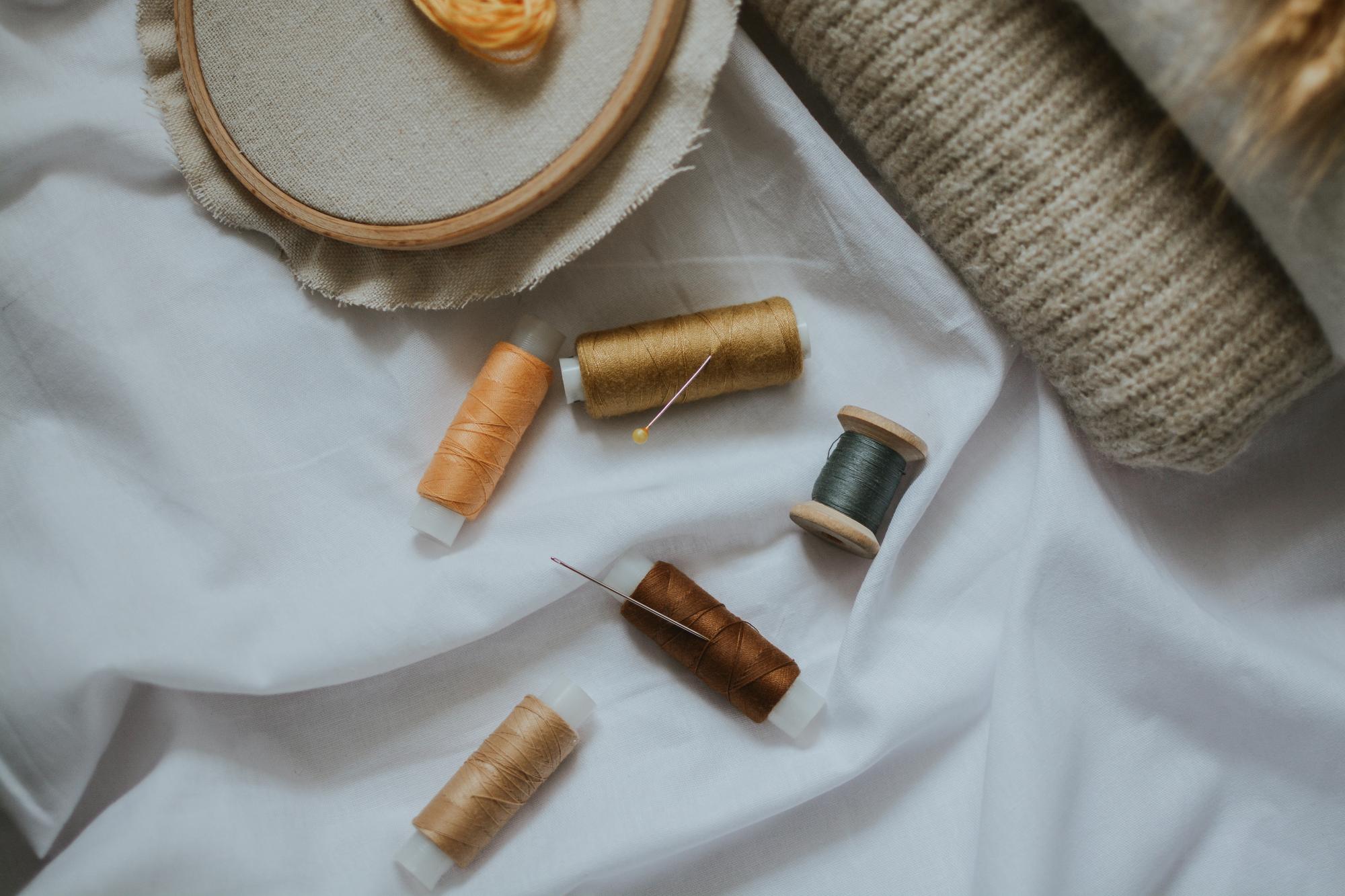 Workspace with threads, needles and linen swatches